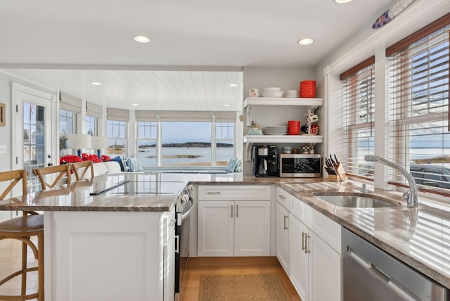 6 Brooks St, Kennebunkport, ME 04046 - kitchen with stainless steel appliances, open shelves, a kitchen bar, a peninsula, and stone counters