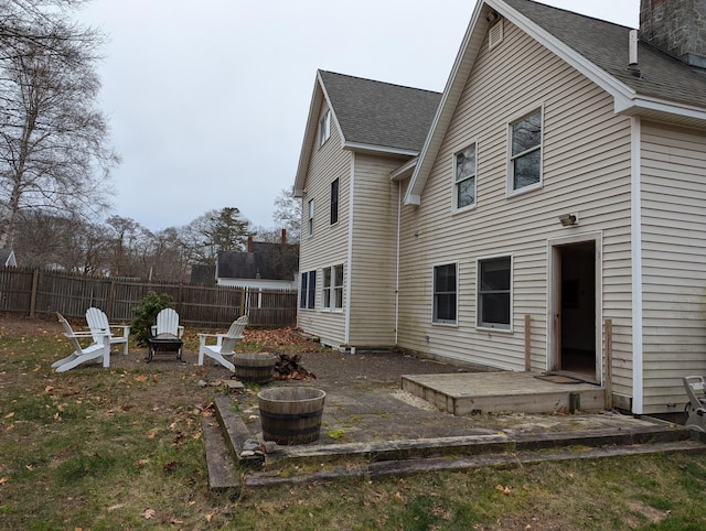 1 Branch St, Camden, ME 04843 - back of property with a patio area, roof with shingles, an outdoor fire pit, and a chimney