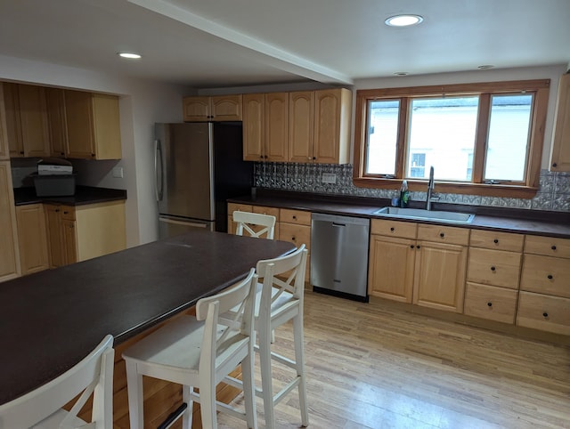 1 Branch St, Camden, ME 04843 - kitchen featuring stainless steel appliances, dark countertops, light wood finished floors, decorative backsplash, and a breakfast bar area