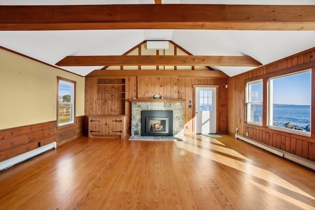 unfurnished living room featuring lofted ceiling with beams, a healthy amount of sunlight, and light hardwood / wood-style flooring