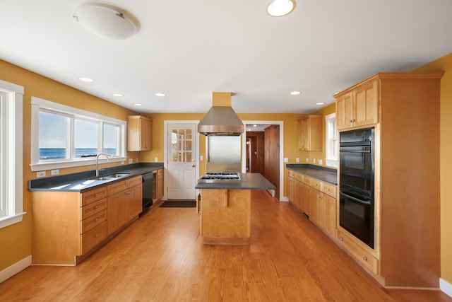 kitchen with sink, a kitchen island, extractor fan, and light wood-type flooring