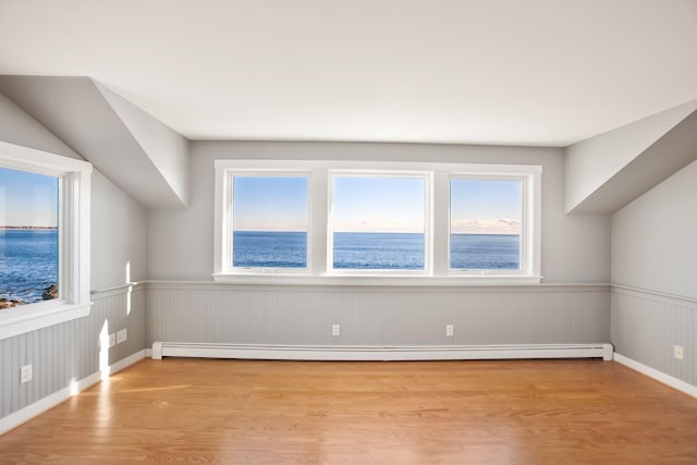 bonus room with light hardwood / wood-style flooring, a water view, and a baseboard heating unit