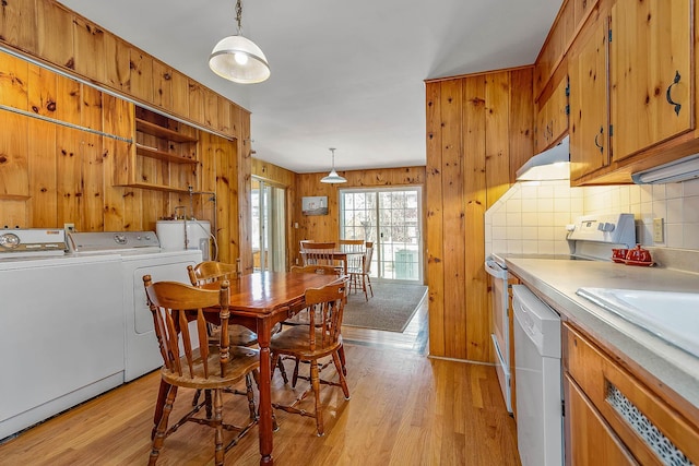 interior space featuring dishwasher, hanging light fixtures, light hardwood / wood-style flooring, washer and dryer, and range