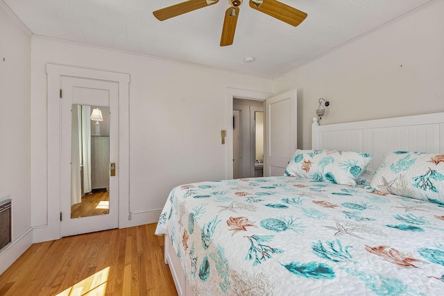 bedroom with ceiling fan, light wood-type flooring, and crown molding