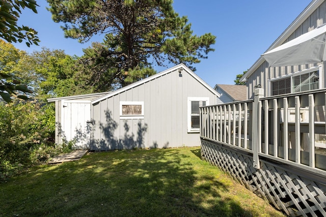 view of side of property featuring a lawn and a deck