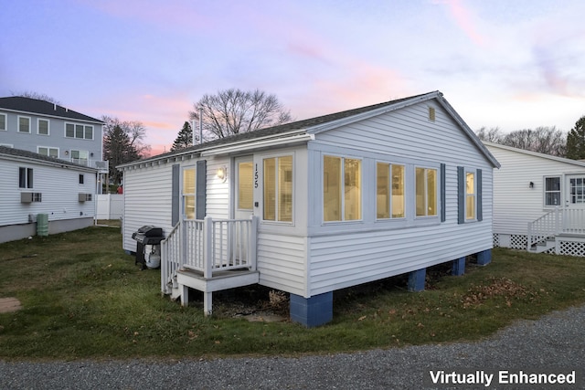 back house at dusk featuring a yard