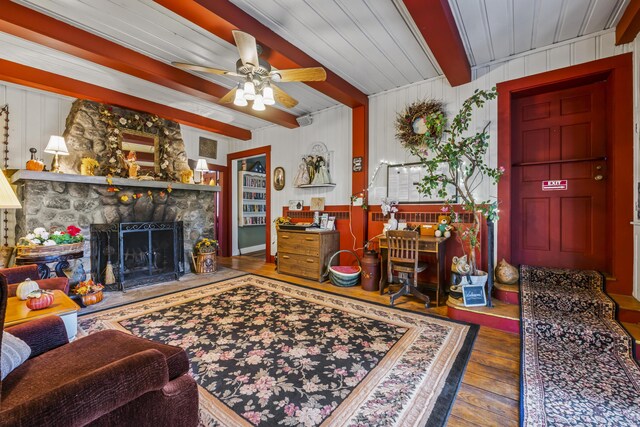 9 Dry Point Dr, Rome, ME 04963 - living room with ceiling fan, wooden walls, beam ceiling, a fireplace, and hardwood / wood-style floors