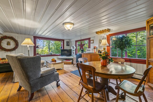 9 Dry Point Dr, Rome, ME 04963 - dining area featuring light hardwood / wood-style floors, wooden walls, and a baseboard radiator