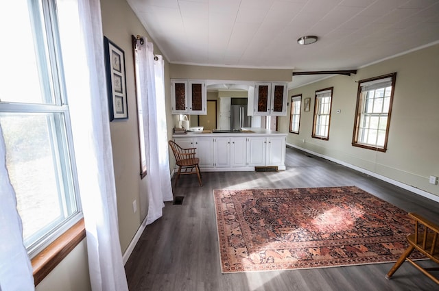 interior space with white cabinets, dark hardwood / wood-style flooring, and ornamental molding