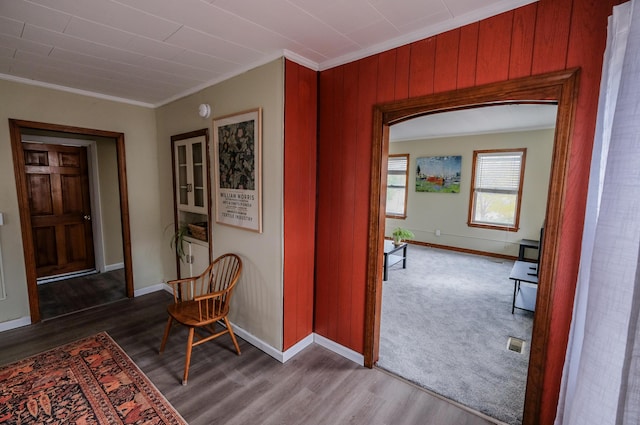 hall featuring wood-type flooring and crown molding