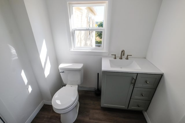 bathroom with toilet, vanity, and hardwood / wood-style flooring