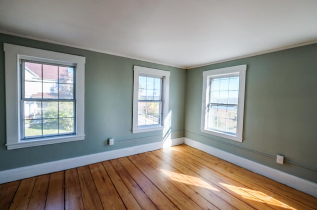 unfurnished room featuring light hardwood / wood-style floors, plenty of natural light, and crown molding