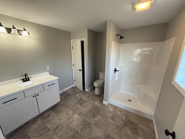 bathroom with vanity, toilet, and a shower