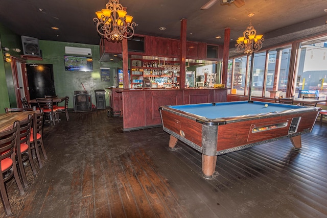 rec room with a wall mounted air conditioner, dark wood-type flooring, a chandelier, bar area, and pool table