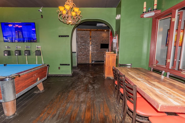 rec room featuring a notable chandelier, brick wall, dark hardwood / wood-style floors, and billiards