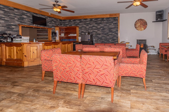 dining area featuring ceiling fan and brick wall