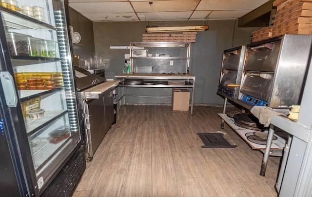 kitchen with hardwood / wood-style floors and a drop ceiling