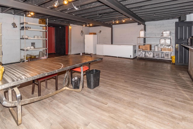 basement featuring hardwood / wood-style floors and white refrigerator