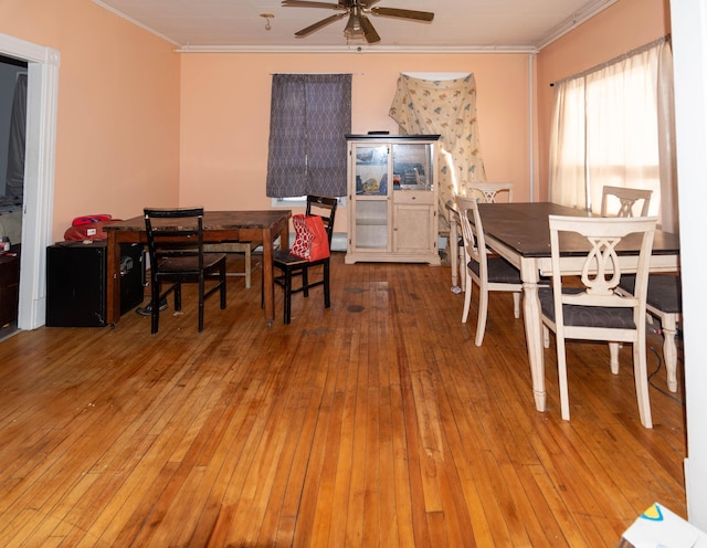 dining area with ceiling fan, wood-type flooring, and crown molding