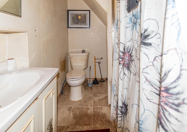 bathroom with tile patterned flooring, vanity, and toilet