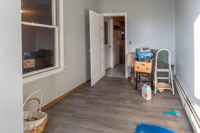 corridor with baseboard heating and dark wood-type flooring