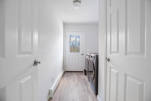 laundry area with washing machine and clothes dryer, light hardwood / wood-style floors, and baseboard heating