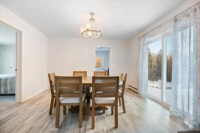 dining space featuring a baseboard radiator, a notable chandelier, and light hardwood / wood-style floors