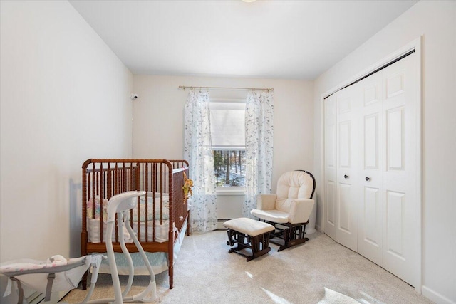 bedroom with light carpet, a crib, and a closet