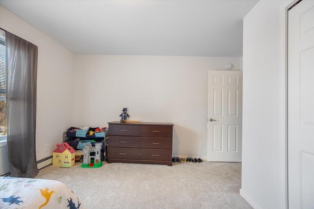 bedroom with light carpet and a baseboard heating unit