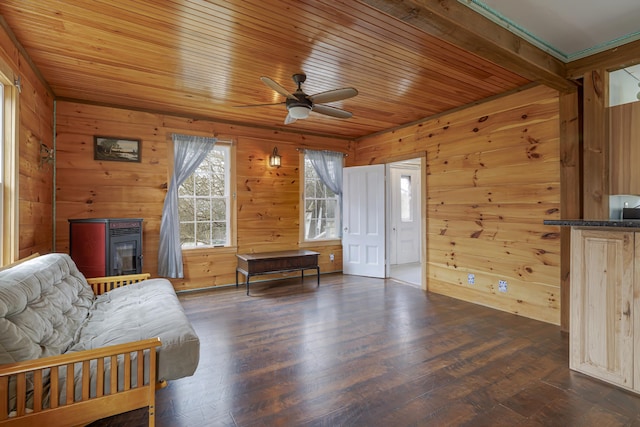 sitting room with wooden walls, ceiling fan, and dark hardwood / wood-style floors