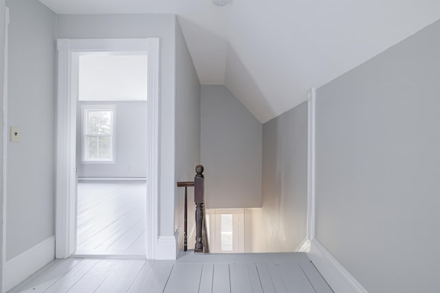 additional living space featuring hardwood / wood-style flooring, baseboard heating, and vaulted ceiling