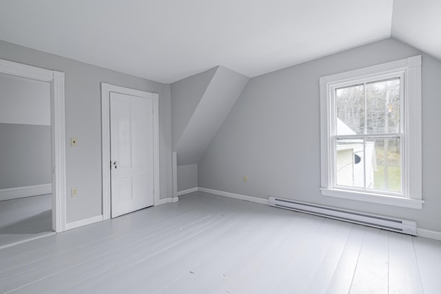 bonus room with lofted ceiling, baseboard heating, and light hardwood / wood-style flooring