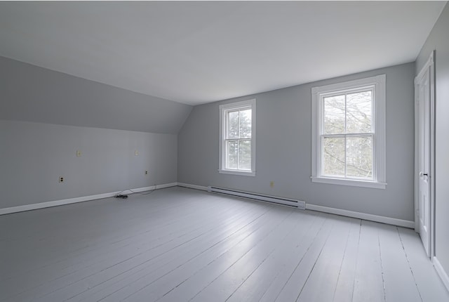 bonus room with lofted ceiling, light hardwood / wood-style floors, and a baseboard heating unit