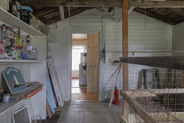 miscellaneous room with hardwood / wood-style flooring, wood walls, and vaulted ceiling