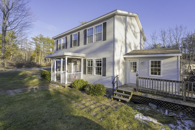 rear view of house with a yard and a wooden deck