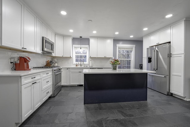 kitchen with sink, pendant lighting, high quality appliances, a center island, and white cabinetry