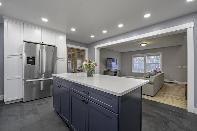 kitchen with french doors, white cabinets, stainless steel fridge, a kitchen island, and dark hardwood / wood-style flooring