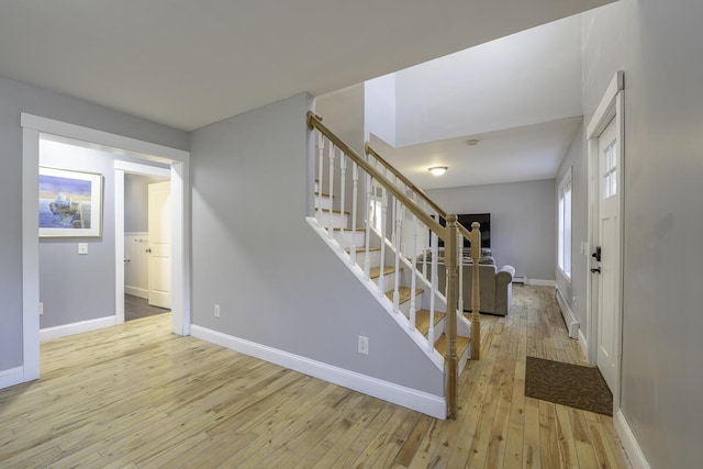 stairs with hardwood / wood-style flooring and a baseboard radiator