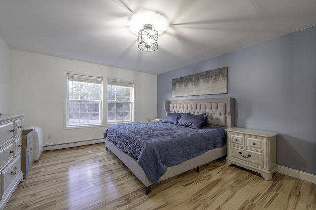 bedroom with light wood-type flooring and baseboard heating