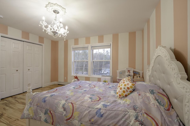 bedroom with a closet, a notable chandelier, and light wood-type flooring