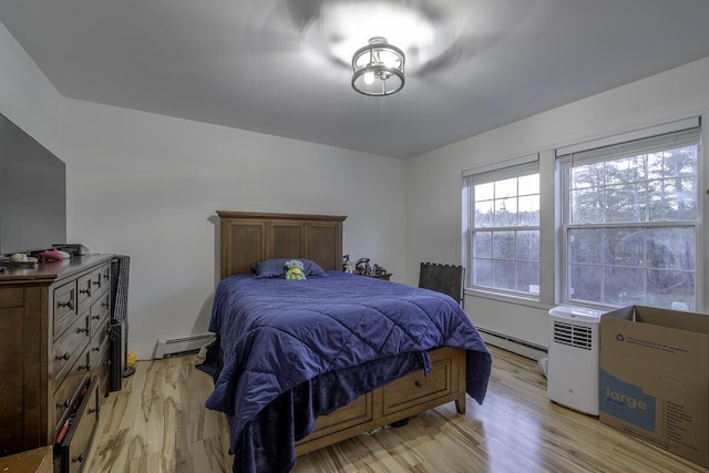 bedroom featuring light wood-type flooring and baseboard heating