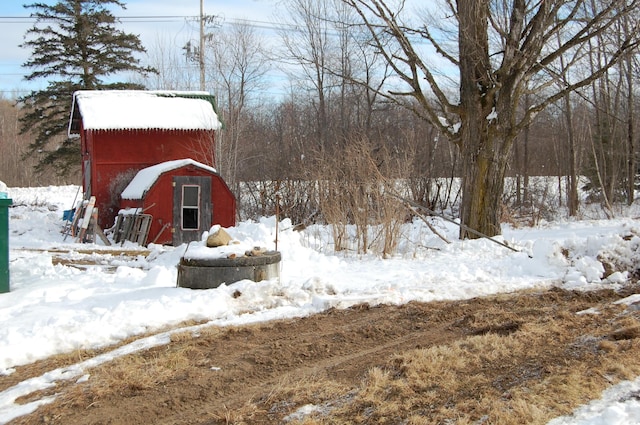 yard layered in snow featuring an outdoor structure