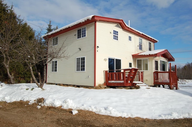 snow covered property with a wooden deck