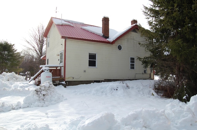 view of snow covered rear of property