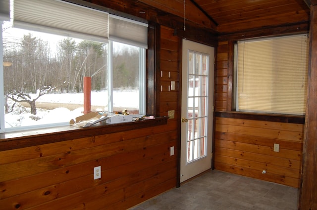 doorway to outside featuring wood walls and wood ceiling