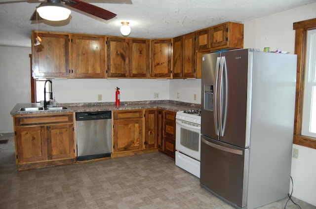 kitchen with ceiling fan, sink, a textured ceiling, and appliances with stainless steel finishes