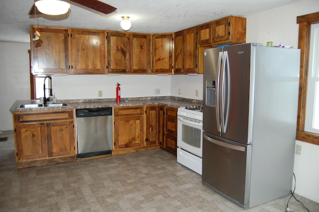 kitchen featuring a textured ceiling, ceiling fan, sink, and appliances with stainless steel finishes