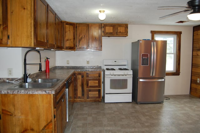 kitchen with a textured ceiling, ceiling fan, sink, and appliances with stainless steel finishes