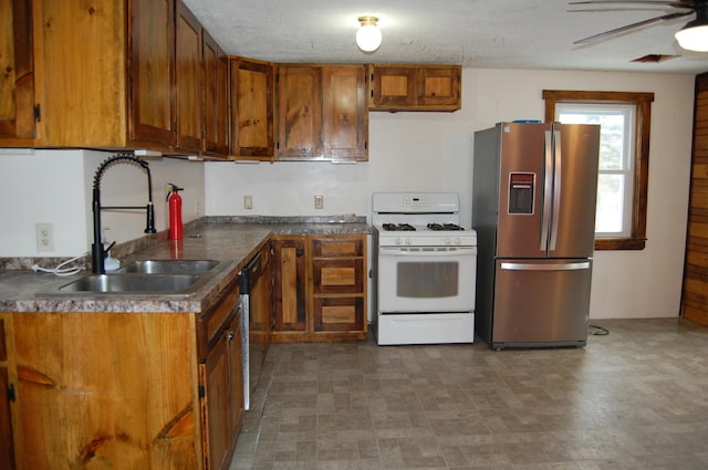 kitchen featuring appliances with stainless steel finishes, a textured ceiling, ceiling fan, and sink