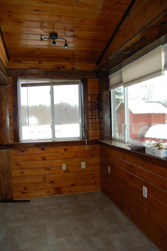 interior space with vaulted ceiling, a healthy amount of sunlight, and wood ceiling